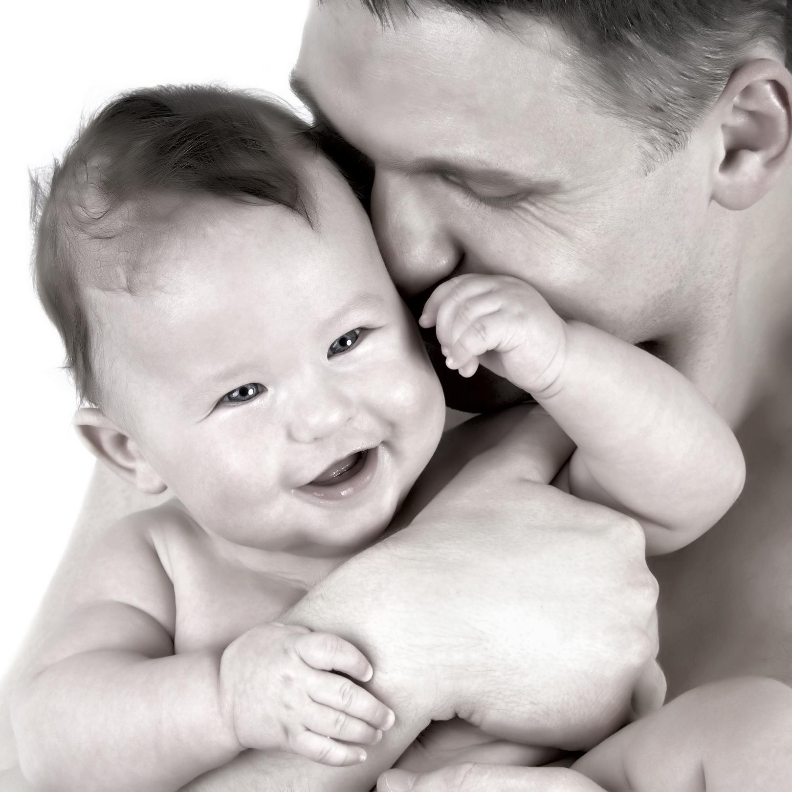 muž drží a líbá dítě